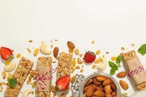 Granola bars, strawberry and almond on white background, top view photo