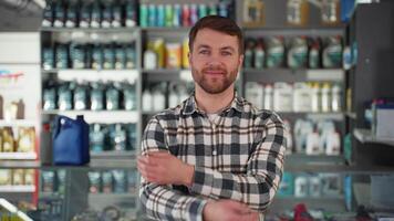 Friendly seller with crossed arms in a car store video