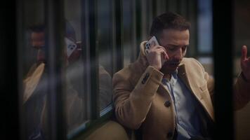 A businessman is deeply engaged in thought while talking on the phone in an urban setting video
