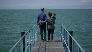 A Family Joyfully Strolling Together on a Beautiful Wooden Pier Near the Calm Waterside video
