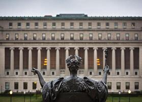 A statue of a woman holding a torch in front of a building photo