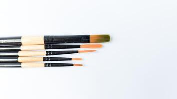 Different brushes with paints on white background photo