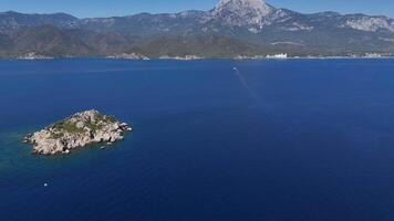 Drone Aerial of Island with Towering Mountains in Open Sea on Sunny Day video