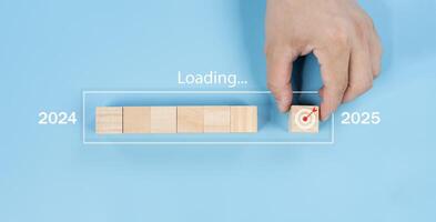 Hand assemble wooden block cube to update technology downloading tool bar status from 2024 to 2025. photo