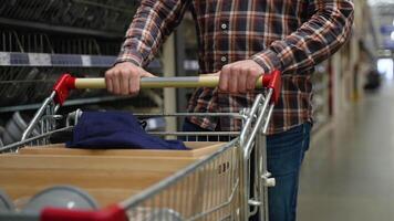 Customer walking with shopping cart in hardware store video