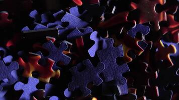 Background of Colored Puzzle Pieces that Rotating Clockwise - Top View, Close-Up. Texture of Incomplete Red and Blue Jigsaw Puzzle with Low Key Light - Right Rotation video