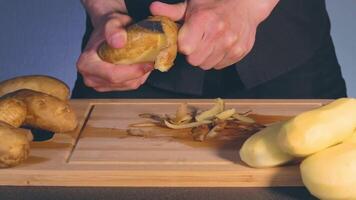 Man in Black Clothing is Peeling Potato and Preparing Ingredients for Cooking Dinner video