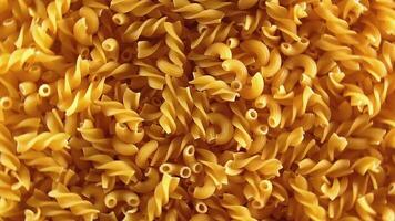 Uncooked Fusilli and Chifferi Rigati Pasta - Top View, Low Key Light. Fat and Unhealthy Food. Classic Dry Macaroni, Rotating Background. Raw Different Macaroni Pasta Texture - Rotate Left video