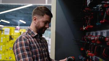 A man in a hardware store chooses a new screwdriver video