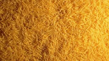 Background of Uncooked Golden Noodles that Rotating Counterclockwise - Top View. Texture of Dry Vermicelli Turning Around. Raw Pasta with Low Key Light - Left Rotation video