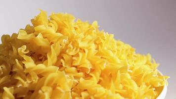 Uncooked Fusilli Pasta Heap Rotating against White Background. Fat and Unhealthy Food. Dry Spiral Macaroni. Italian Culture and Cuisine. Raw Golden Pasta video
