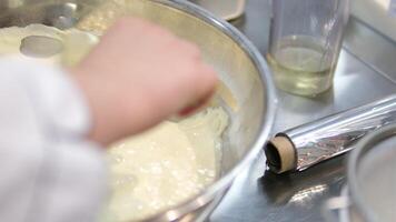 Add flour to. woman's hand mixes the dough with the added flour with a spoon. Making pastries at home. video