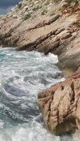 The waves breaking on a stony beach, forming a spray. Footage. Splashing waves on the rocks of the sea video