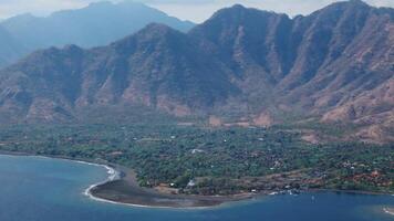 panorama dentro oeste bali com azul oceano e cênico montanhas dentro permutador, aéreo Visão video