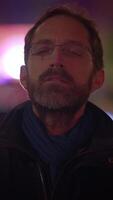 A contemplative man stands in a vibrant urban nightscape, embracing the citys serenity video