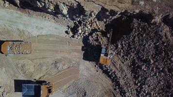 Quarry mining, work of the excavator and dump trucks, aerial view video