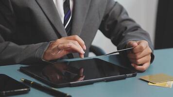A man in a suit is using a tablet computer video