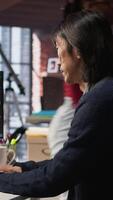 Vertical Software engineer in small business workspace using computer to oversee artificial intelligence neural networks. Person in tech startup office using AI machine learning systems on PC, camera A video