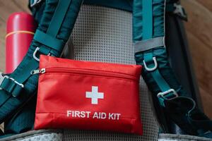 A first aid kit is securely attached to the back section of a useful backpack, ensuring that medical supplies are readily accessible in case of any emergencies while on the go photo