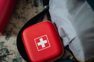 A bright red first aid kit is securely placed inside of a sturdy backpack, ready for any emergency situations that may arise during your outdoor adventures or daily activities photo