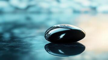 Polished Black Stone with Reflection on a Smooth Surface, Perfect for Zen Concepts, Minimalist Design, Meditation Themes, Spa Decor, and Nature-Inspired Tranquility photo