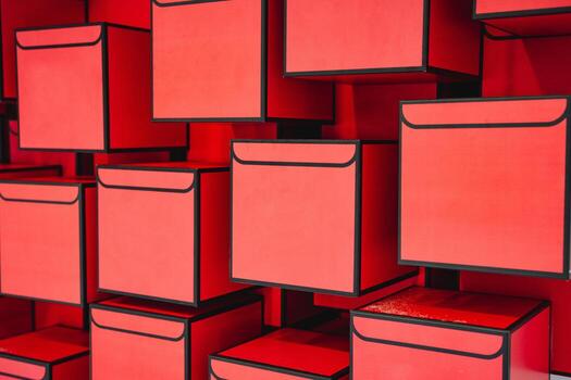 A large group of vibrant red boxes are neatly stacked one on top of another in a visually appealing manner, creating a striking arrangement of colors and design elements photo