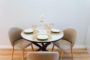 A beautifully arranged dining table set, complete with meticulously placed plates and elegant glasses, creates an inviting atmosphere for hosting memorable meals with loved ones and friends photo
