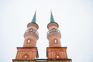 A sturdy brick building features two impressive towers that rise majestically atop its structure, enhancing its architectural beauty and serving as a notable landmark in the area photo