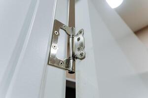 This image showcases a detailed close up view of a door hinge positioned on a pristine white door, highlighting the intricate design and functionality of this essential household hardware photo