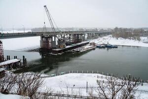 Currently, a bridge is under construction that spans a vast expanse of water, which will facilitate easier transportation and connectivity across this significant geographic feature photo