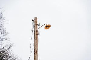 A strong, durable wooden pole that is topped with a bright, illuminating light brightens up the night and poorly lit areas, ensuring the safety and visibility of everyone who is nearby photo