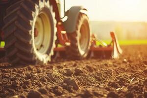 Tractor plowing field at sunrise, agricultural machinery in action photo