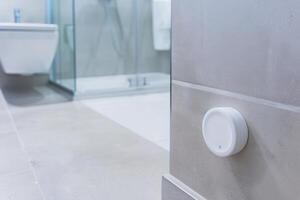 Modern bathroom interior with smart temperature sensor on wall photo