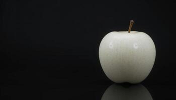 A Single White Apple Against a Black Background. A Study in Contrast and Minimalism photo
