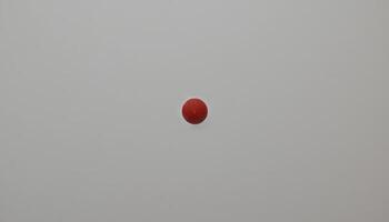 A Single Red Sphere Against a Neutral Background. Minimalist Photography Study photo