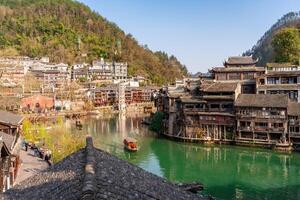 Feng Huang Ancient Town and tourist boats on Tuo Jiang River, The famous tourist destination at Hunan Province, China photo