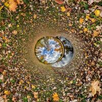 A circular hole in the ground with leaves on it photo