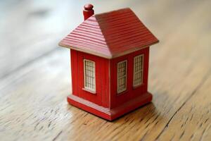 A small toy house placed on a wooden background, symbolizing the concept of homeownership and the process of buying a house in a creative and symbolic way photo