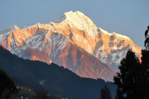 An evening view of the Himalayas in Uttarakhand, India, with majestic mountain peaks and the warm glow of the sunset, creating an atmosphere of tranquility and the grandeur of nature photo