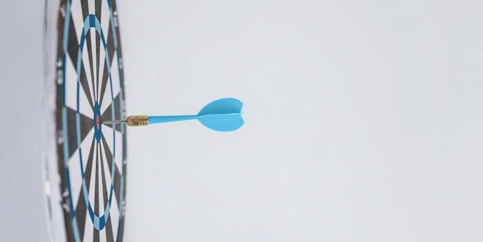 Blue dart embedded in the center of a target, symbolizing success, precision, and making the right moves to achieve goals effectively photo