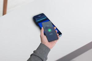 Smartphone completing a payment on a POS terminal with a wireless symbol and a Payment Successful message displayed, showcasing the concept of seamless mobile transactions photo