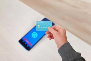 Credit card hovering over a POS terminal with a glowing contactless payment icon, illustrating modern NFC payment technology and seamless transactions photo