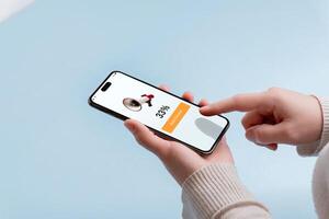 Smartphone held in hand displays a shopping app with a megaphone icon and 33 OFF message featuring an Apply Discount button for savings photo