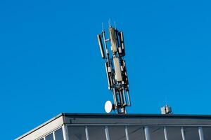 A cell tower and satellite dish are positioned on the rooftop of a photo