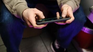 Young man playing mobile game with fast finger movements and colorful pulsating hand lights, dynamic gameplay, close up phone screen, digital entertainment, gaming action, energetic gaming session. photo