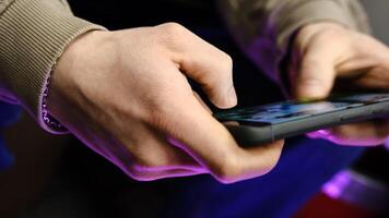 Young man playing mobile game with fast finger movements and colorful pulsating hand lights, dynamic gameplay, close up phone screen, digital entertainment, gaming action, energetic gaming session. photo