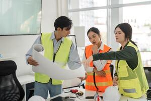 Construction team collaboratively reviewing project blueprints and discussing plans in modern office photo