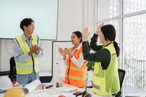 Celebrating a successful project milestone. construction team members applauding in a modern office setting photo