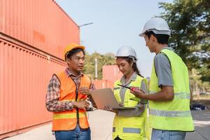 Logistics engineering team collaborating on a laptop while discussing project objectives at a construction site photo