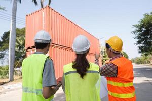 Construction team evaluating the project site and discussing plans with blueprints at a construction area photo